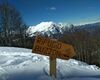 Cartello sentiero invernale Rifugio Buzzoni, sullo sfondo la Grigna
